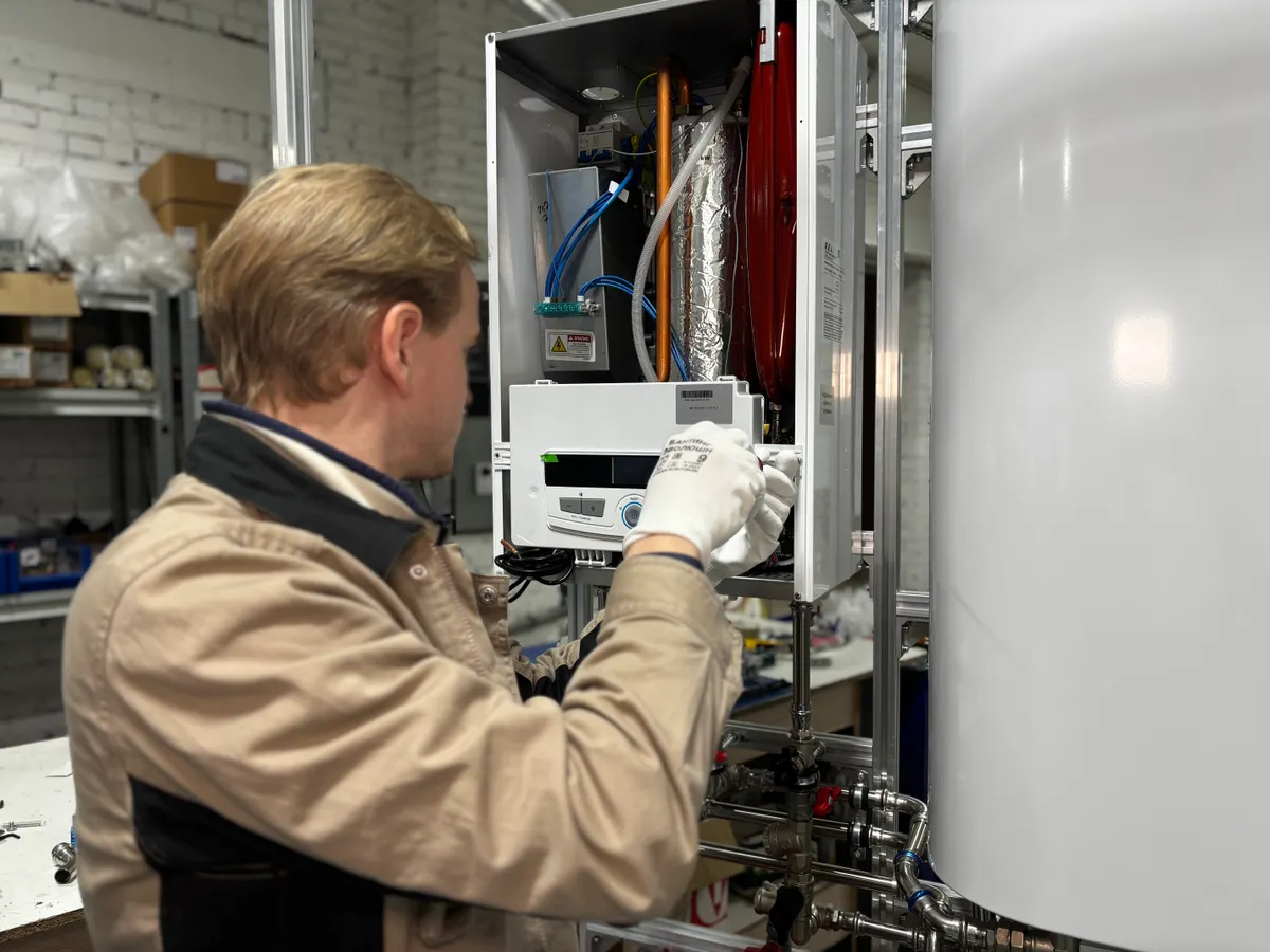 A technician inspecting an open heating unit